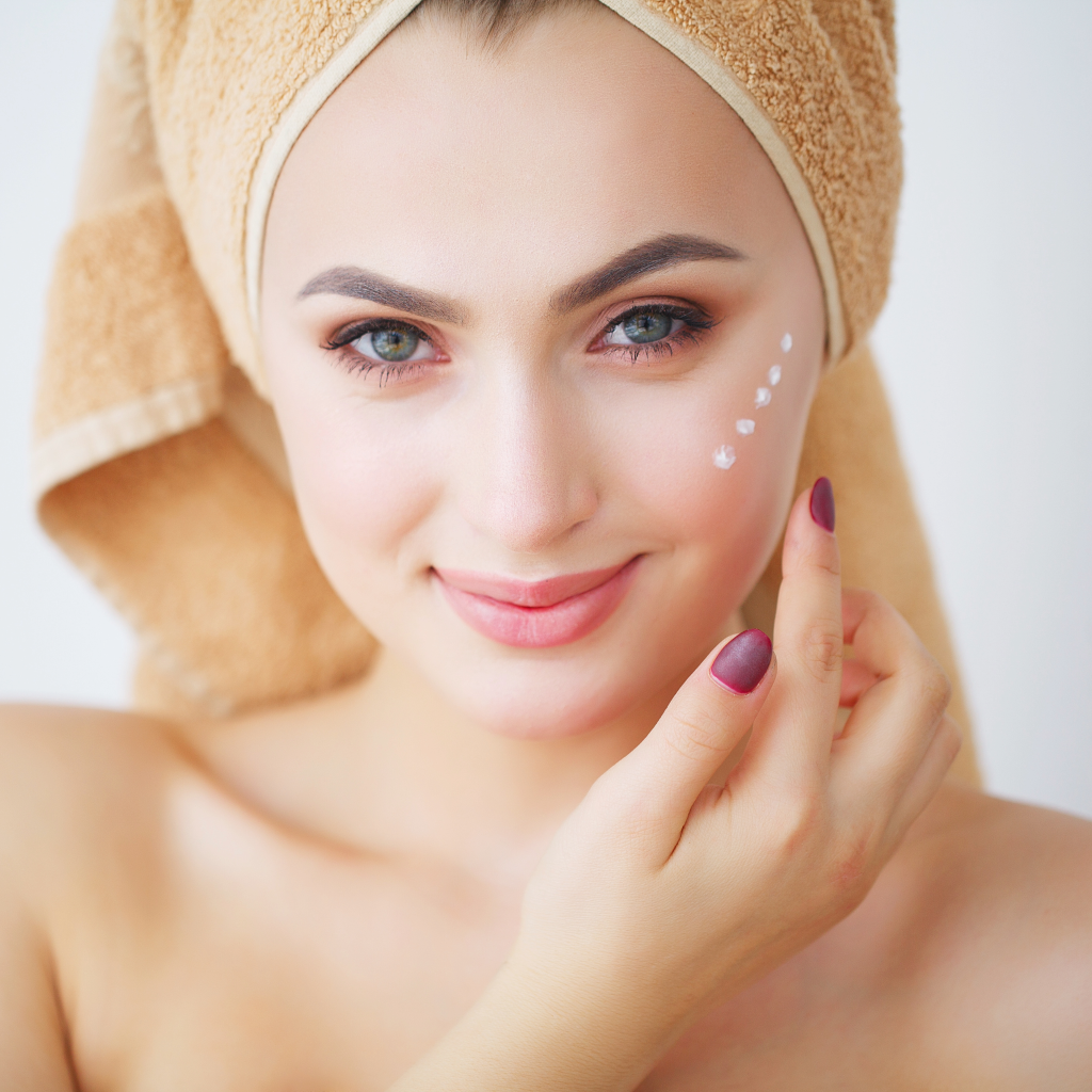 Woman applying natural snail cream on her face — glowing hydrated skin with HeliRoyal Plus Slovenian skincare.